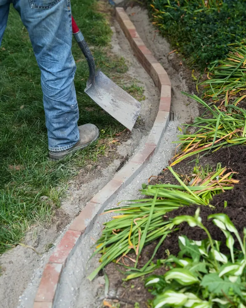 Brick paver bed edging installation along a landscape bed in Dayton, OH